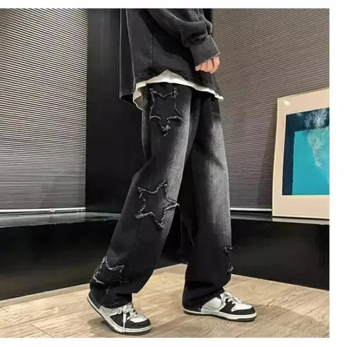 Black star-embroidered ripped jeans with sneakers, modern streetwear style