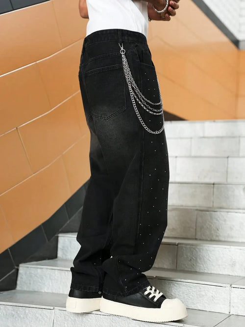Black studded jeans with chain detail, paired with white tee and chunky sneakers for urban streetwear style